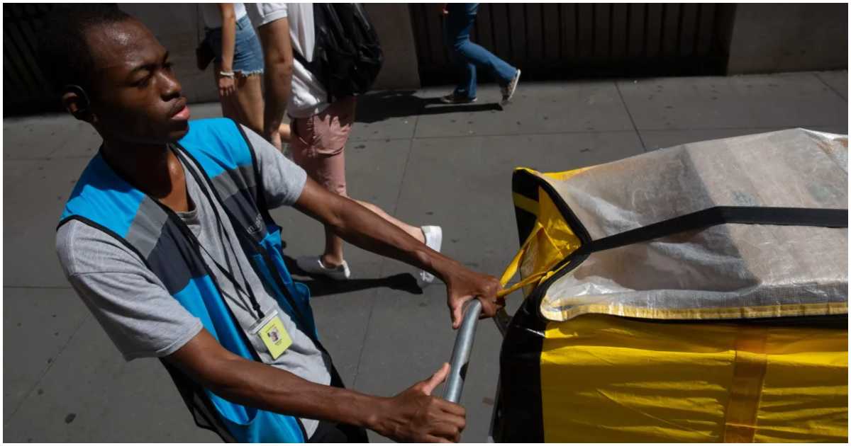 নিউ ইয়র্ক সিটির ম্যানহাটনের ব্রড স্ট্রিটে ২০২৩ সালের ৫ সেপ্টেম্বর কর্মরত এক ডেলিভারি সার্ভিস কর্মী। ছবি: বেন ফ্র্যাকটেনবার্গ/দ্য সিটি